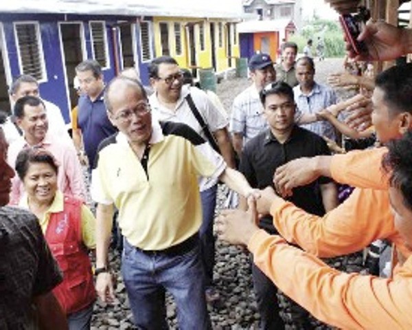 President Aquino takes time out for a photo-op while inspecting the controversial bunkhouses (Photo : getrealphilippines.com)