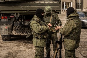 MARCH 5 2014: Russian troops without chevrons and distinctive signs, near of the truck without license plates (March 5, 2014) Sergii Morgunov / Shutterstock