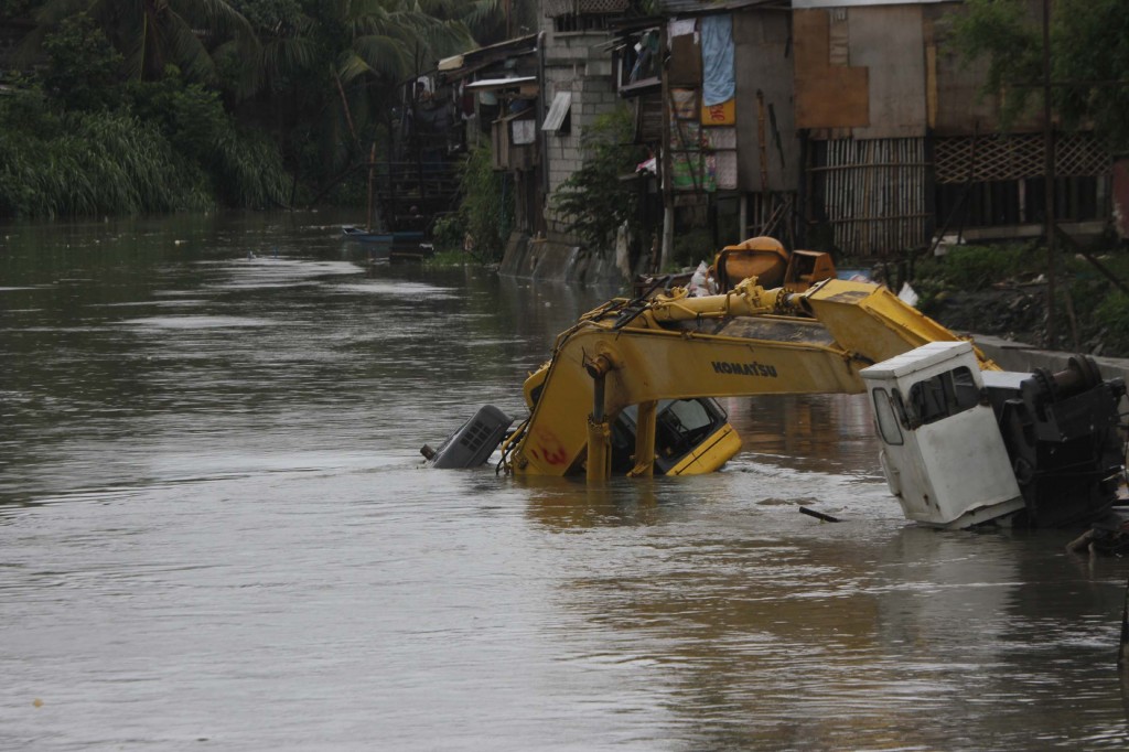 Photo shows a heavy equipment half-submerged in the swollen water of Bacoor River in Bacoor City, Cavite on Friday (Sept. 19, 2014). (PNA photo by Avito C. Dalan)