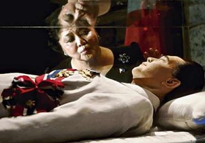 Imelda Marcos kisses the encasement of her late husband's body.  (Photo from http://scrapetv.com)