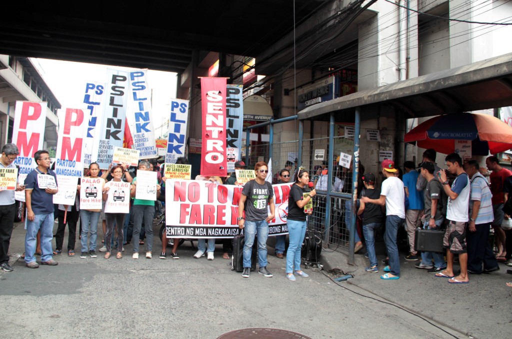 Workers hold a rally in front of the Metro Rail Transit (MRT) 3 North Avenue Station in Quezon City on Monday (Jan. 5, 2015) to express opposition to fare increases of the MRT and Light Rail Transit (LRT) Lines 1 and 2. (PNA photo by Jess M. Escaros Jr.)
