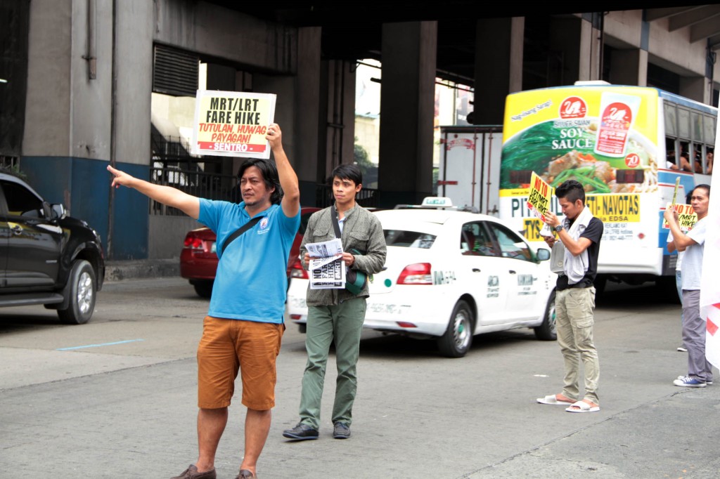 Workers hold a rally in front of the Metro Rail Transit (MRT) 3 North Avenue Station in Quezon City on Monday (Jan. 5, 2015) to express opposition to fare increases of the MRT and Light Rail Transit (LRT) Lines 1 and 2. (PNA photo by Jess M. Escaros Jr.)