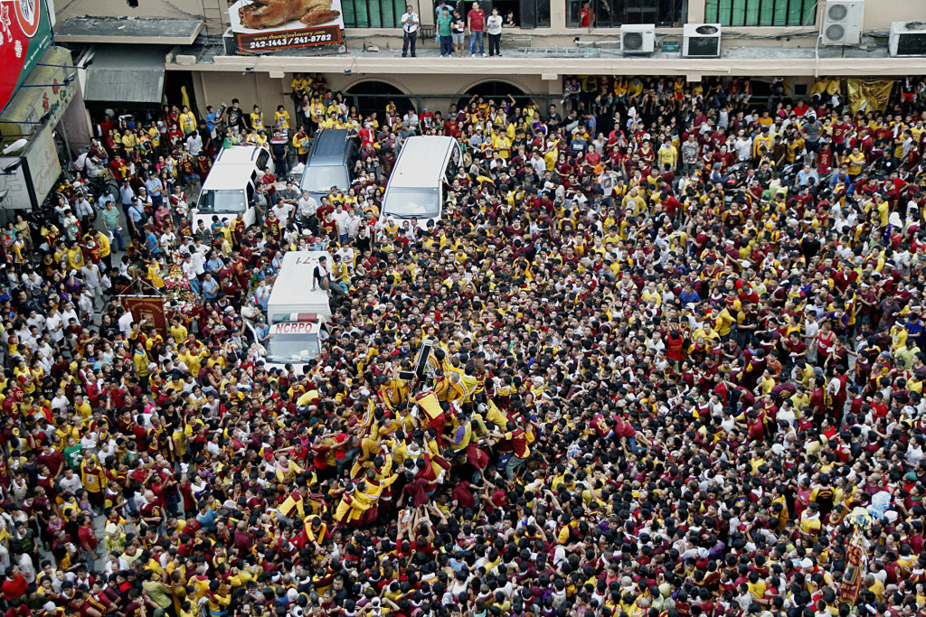 Hundreds of thousands devotees line up the streets of Manila to await the Procession of the Black Nazarene on Friday (Jan. 9, 2015). Photo shows the crowd along Escolta St., Binondo, Manila as the Black Nazarene passes on its way back to Quiapo Church. (PNA photo by Oliver Marquez) 