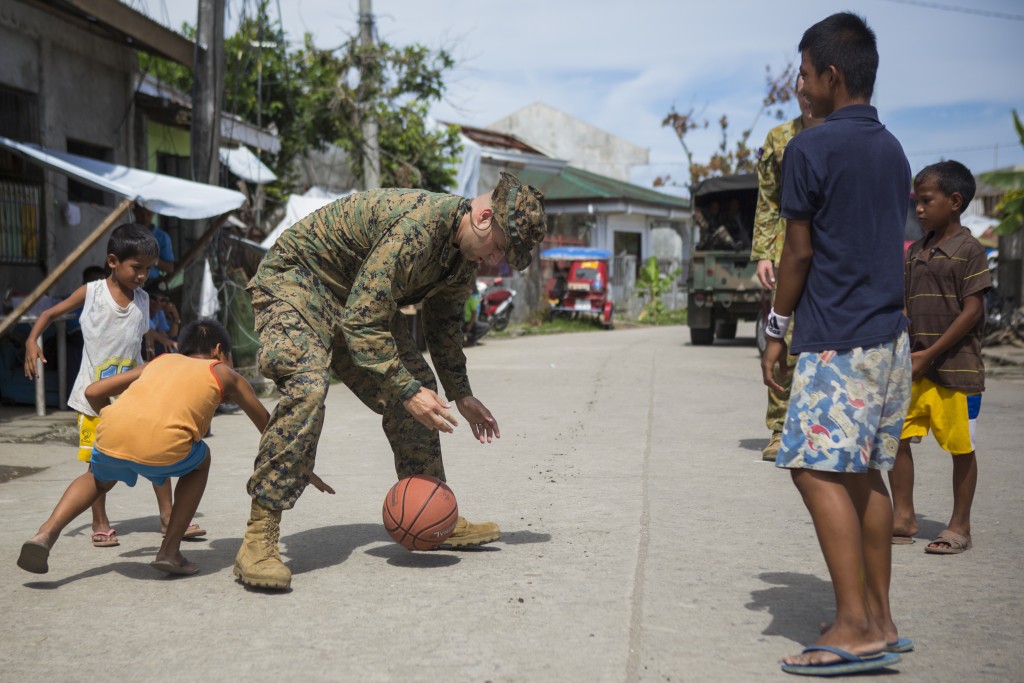 TACLOBAN, Philippines - U.S. Navy HM2 Christopher Marsh, corpsman, with 1st Marine Division, stationed at Camp Pendleton, Calif., plays basketball with local Philippine children during a cooperative health engagement during Balikatan 2014 at Fishermans Village Elementary School, Tacloban, Republic of the Philippines, May 10, 2014. The Armed Forces Philippines and U.S. have had a long-standing relationship and welcome the Australian Defence Forces increasing participation in Balikatan. (Lance Cpl. Allison DeVries / US Marines website)