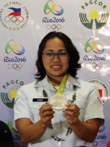 A beaming Olympian Silver Medalist Hidilyn Diaz displays her medal shortly upon her arrival at the Ninoy Aquino International Airport (NAIA) Terminal 3 in Pasay City from Rio de Janeiro, Brazil. (Photo: Avito Dalan/PNA)