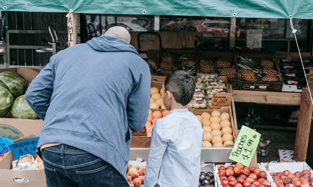 Father and son standing in the fruit market