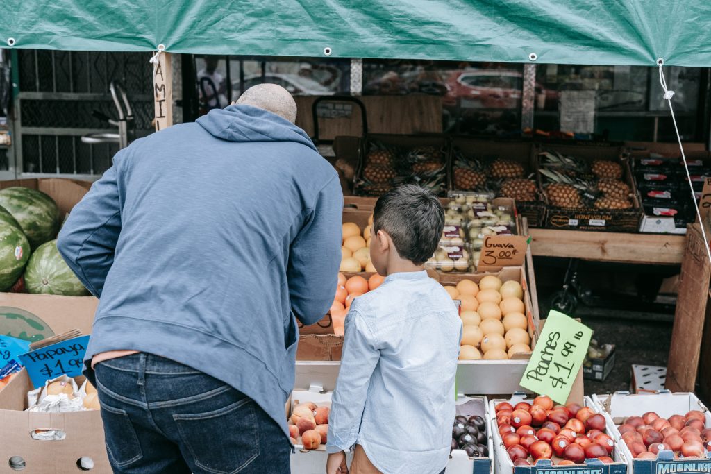 Father and son standing in the fruit market