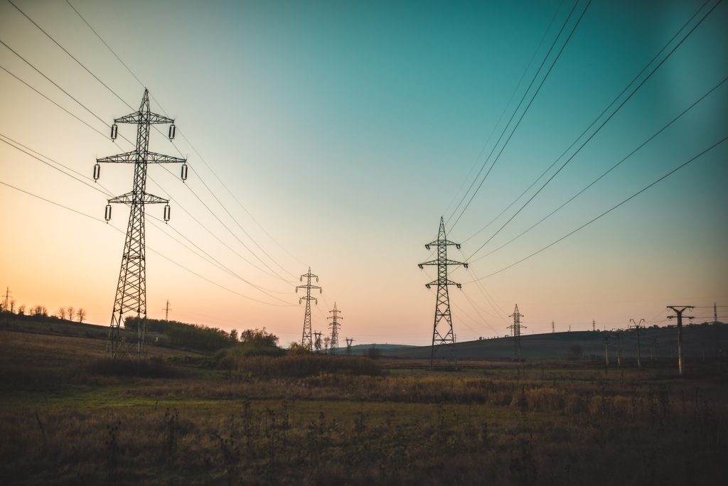 Landscape photography of electric towers under a calm blue sky