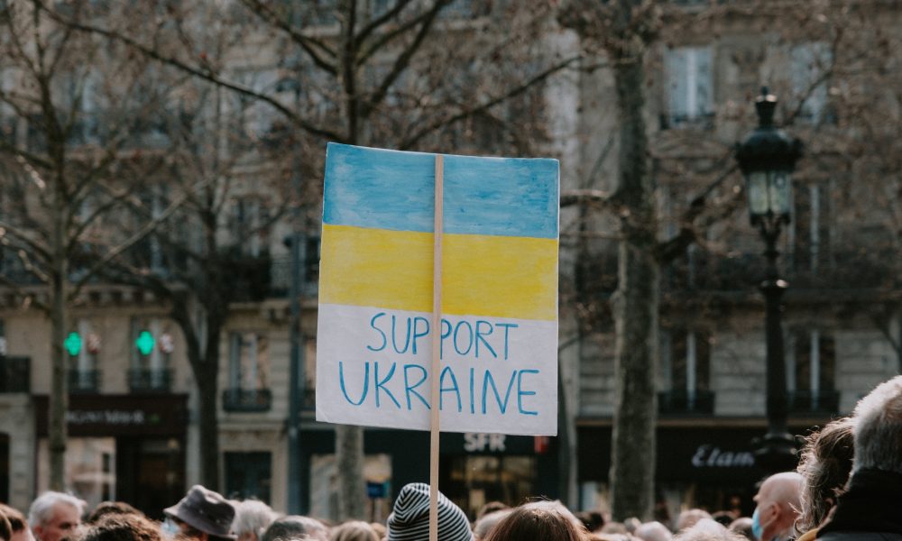Large group of people holding banner on supporting Ukraine