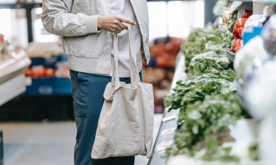 Unrecognizable customer near greens in supermarket