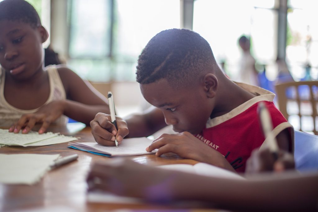 black kid writing on paper