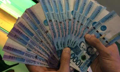 hands holding one-thousand peso bills