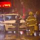 Police and firefighters work at the rear of an auditorium where a gunman shot and killed at least one person during the Parti Québécois victory rally