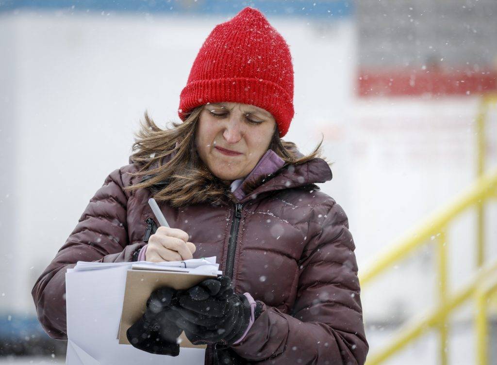 Deputy Prime Minister Chrystia Freeland writing in a paper she's holding