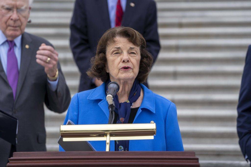 Senator Dianne Feinstein wearing blue in front of the podium