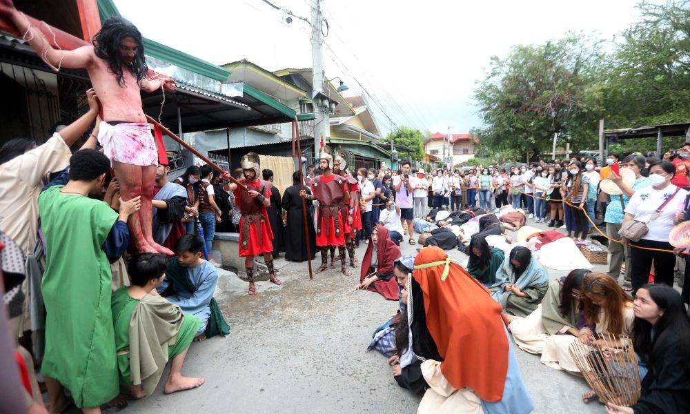 In costumes and with full props like a big cross and wooden spears, Catholic devotees reenact the Way of the Cross