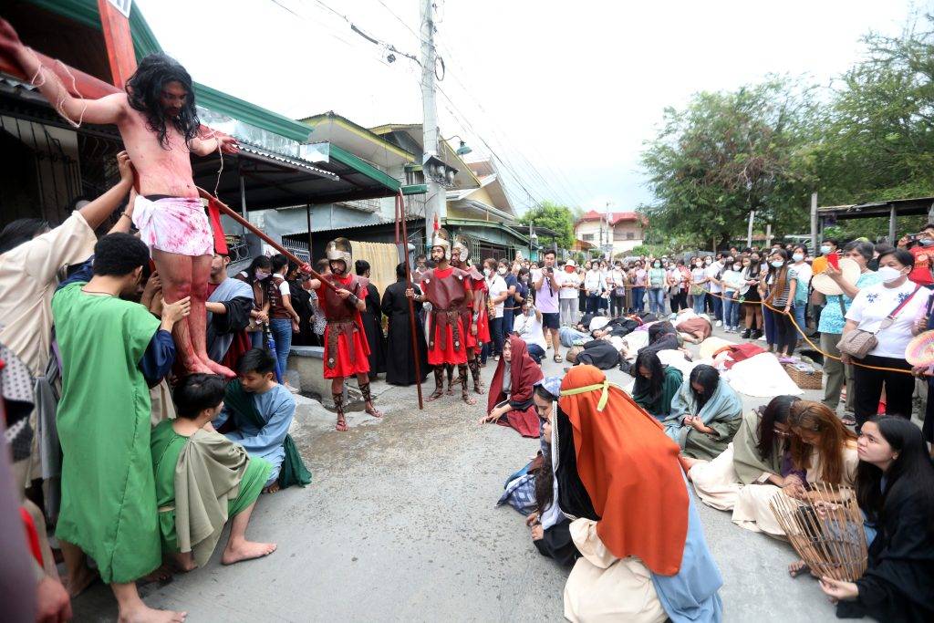 In costumes and with full props like a big cross and wooden spears, Catholic devotees reenact the Way of the Cross