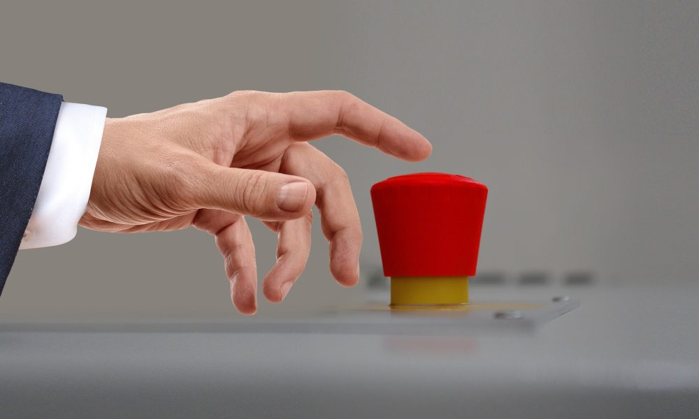 Hand about to press a red button