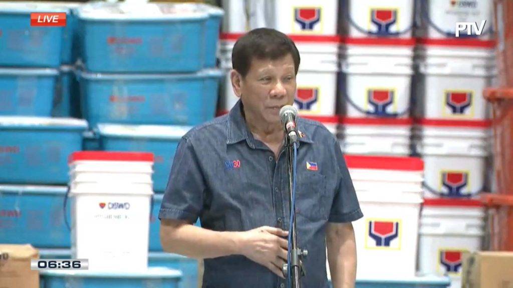 Pres. Duterte speaking with relief goods at the back, in Leyte