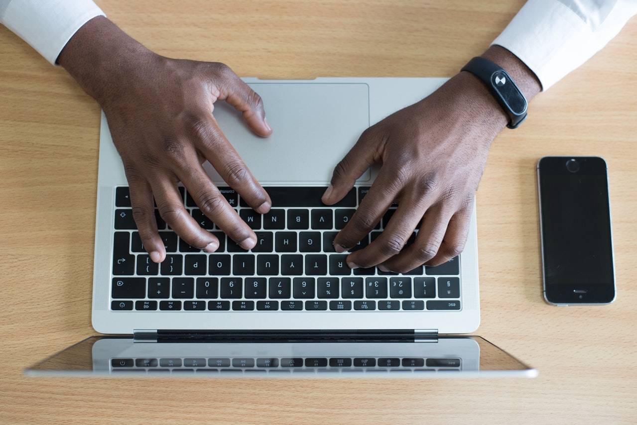 hands typing on a laptop keyboard