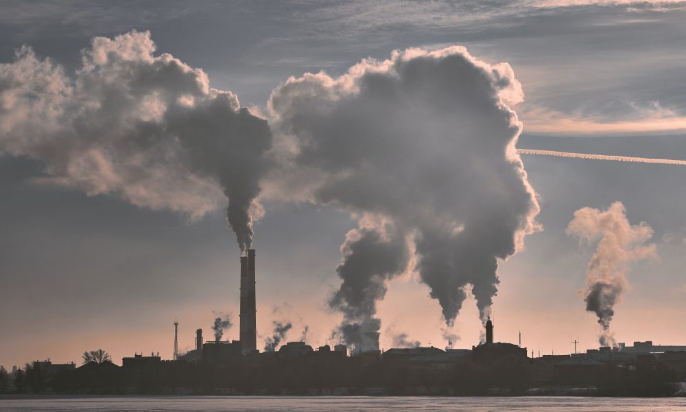 Silhouette of industrial building billowing smoke
