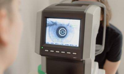 ophthalmologist checking eyesight of woman on vision screener