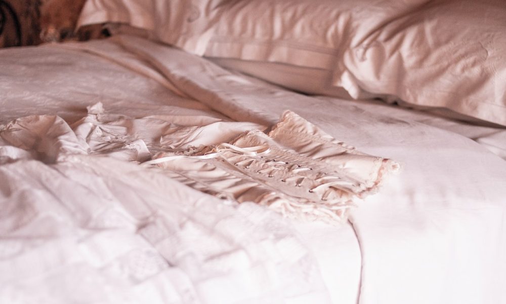 white corset laid on a bed