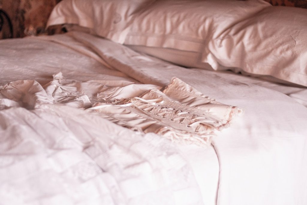 white corset laid on a bed