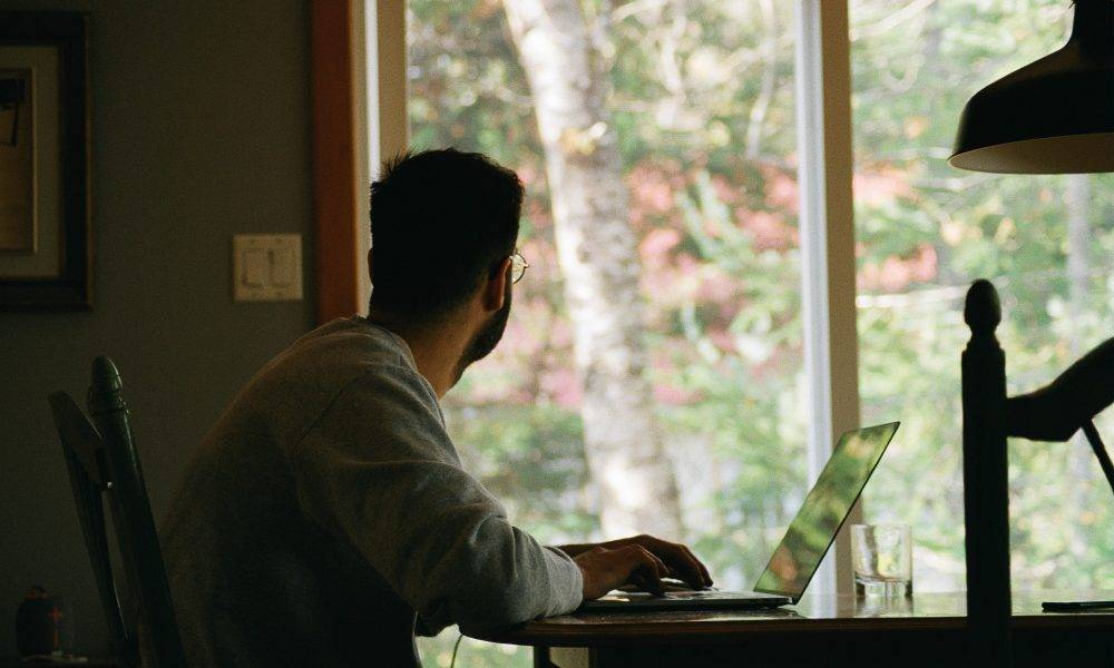 Man in hoodie using a laptop