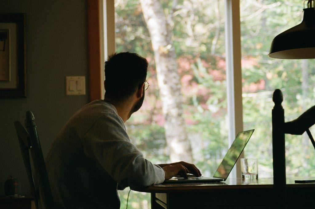 Man in hoodie using a laptop