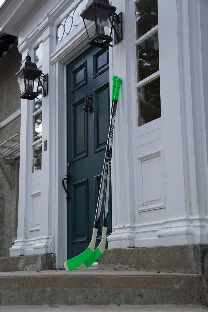 green hockey sticks by the door