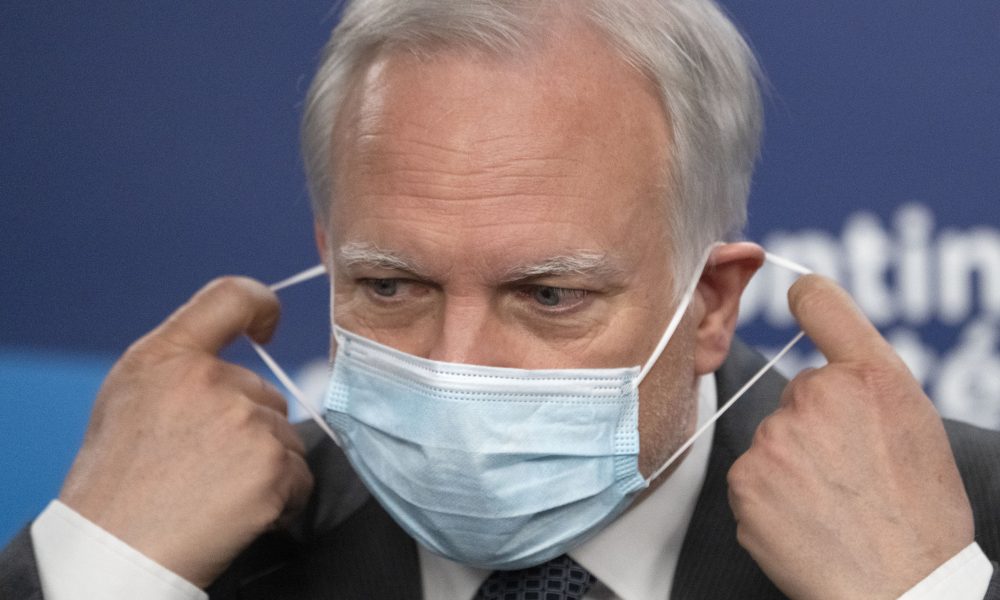 Quebec interim health director Dr. Luc Boileau removes his mask