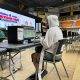 Person in a white hood in front of a computer