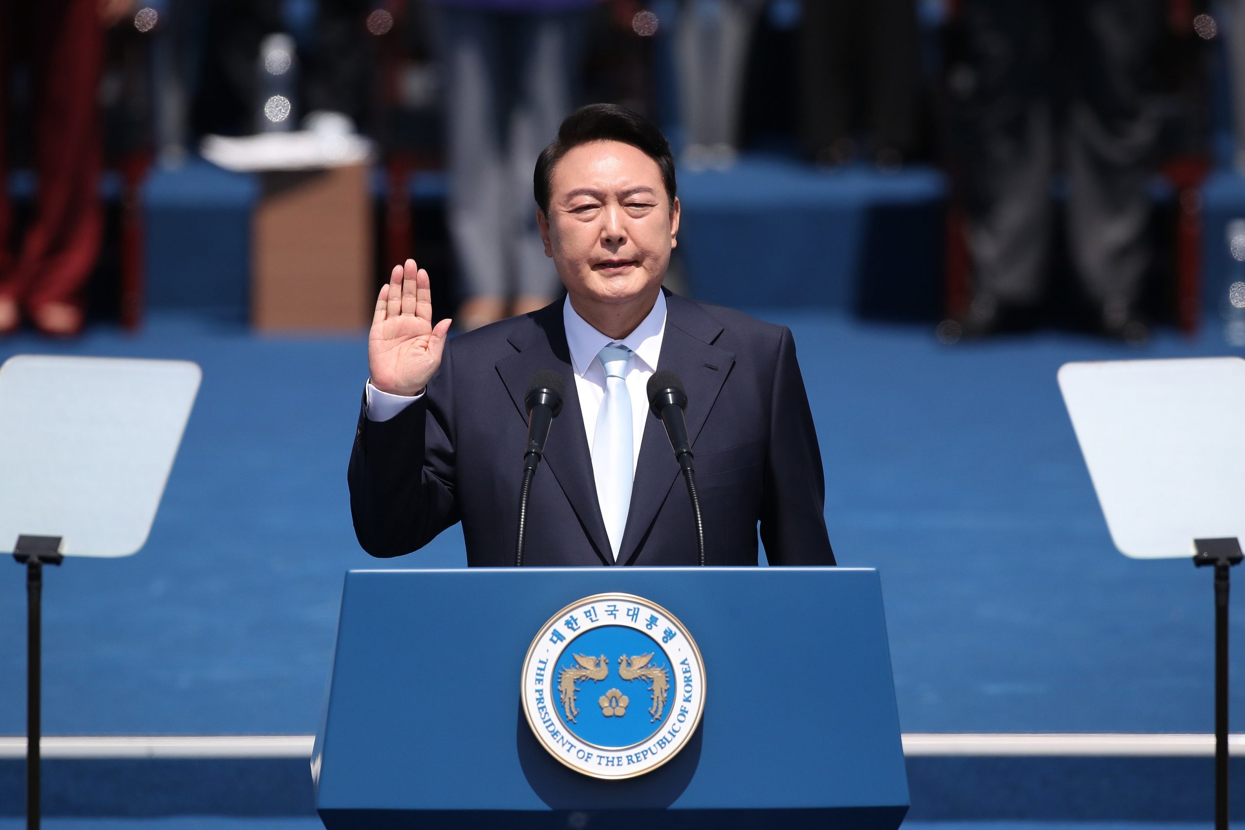 Yoon Suk-yeol with his hand raised in front of a podium during the inauguration ceremony