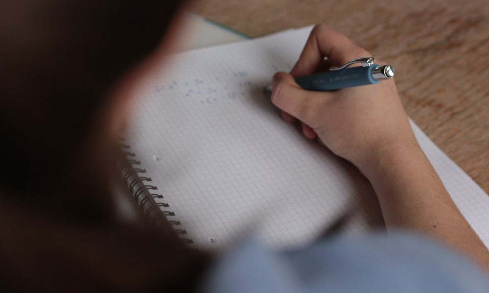 Person writing on a notebook