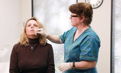 a nurse administering a dosage of nasal vaccine on a lady patient