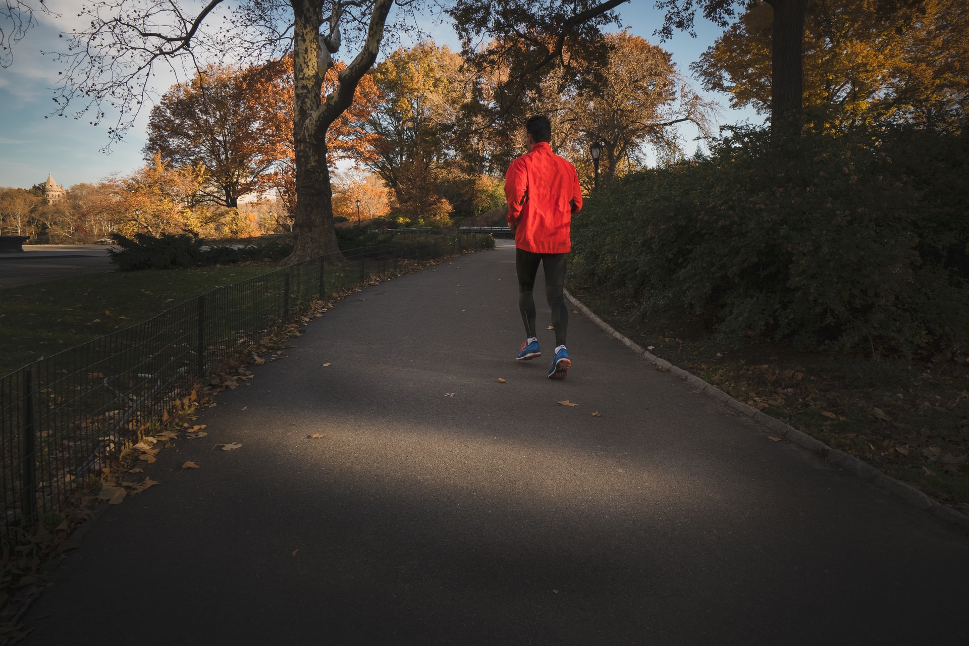 Man in orange jogging in an empty road