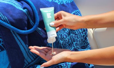 person holding blue plastic tube of cream