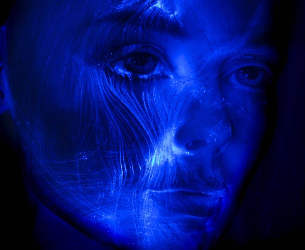 Futuristic light painting of a woman portrait, veins of fibre optic light passing through her face.