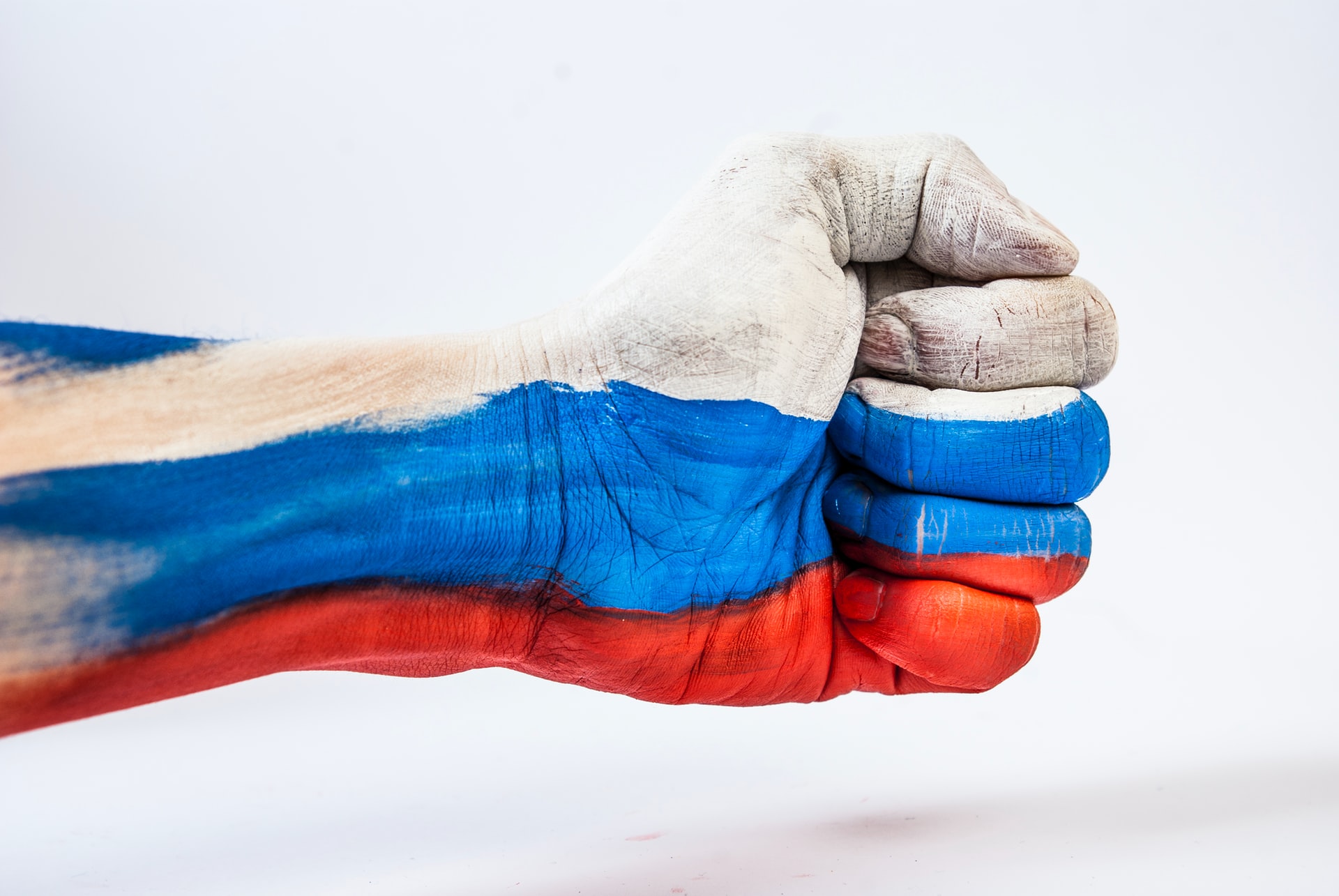 Close fist painted with Russian flag colors