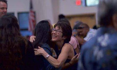 Woman with glasses hugging another woman