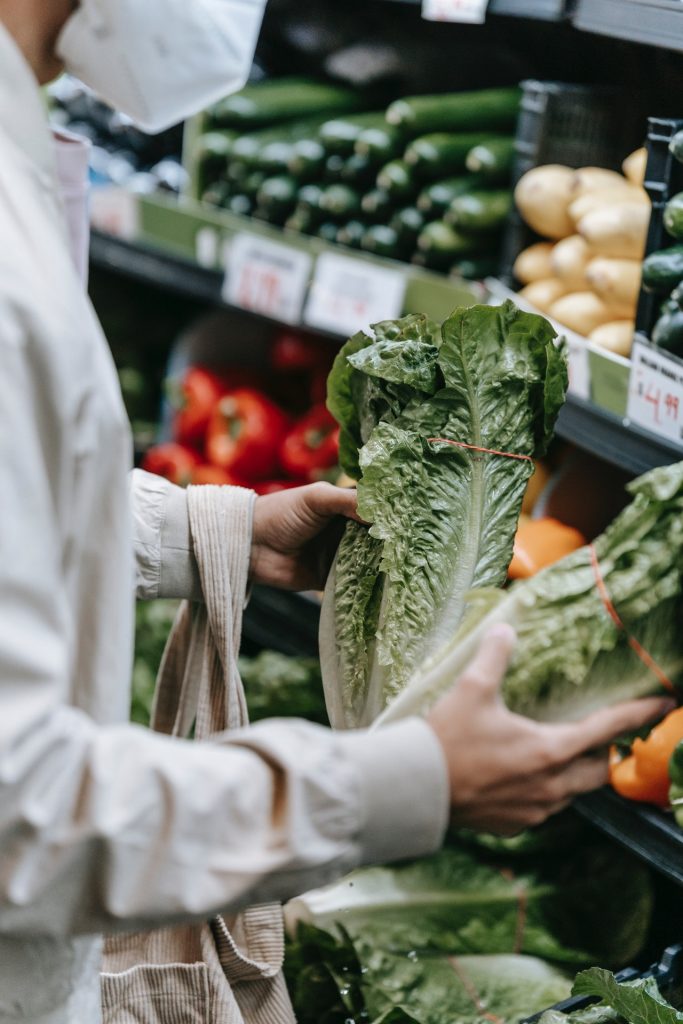 man picking lettuce in grocery