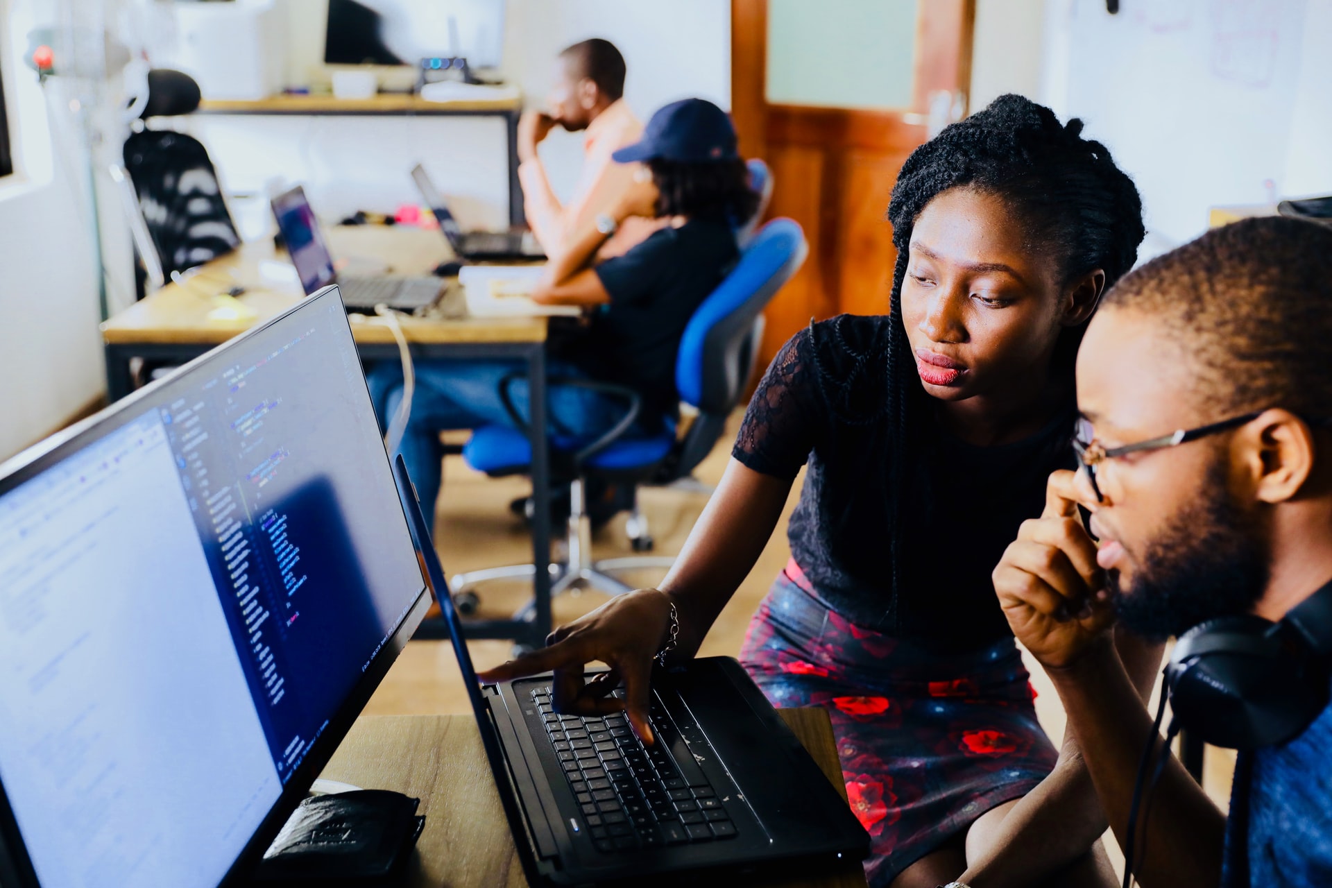 Two people in front of a monitor in an office