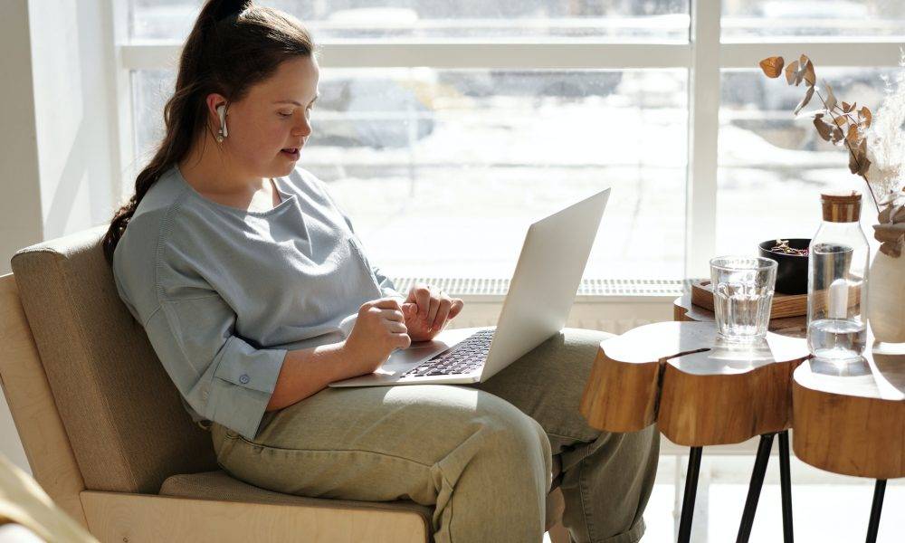 girl sitting on a couch with a laptop