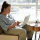 girl sitting on a couch with a laptop
