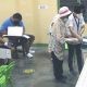 senior citizen feeds her ballot into the vote-counting machine