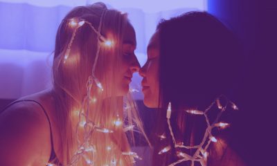 Two people facing each other with fairy lights on them