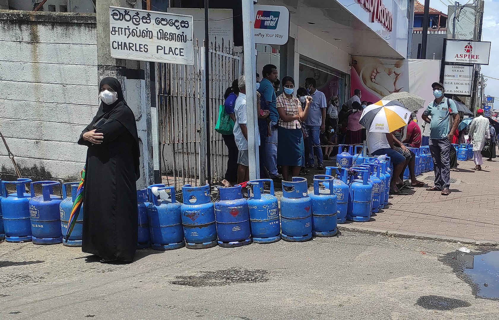 People in line with gas tanks
