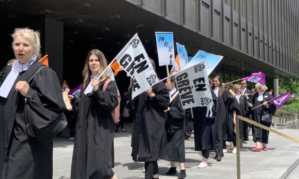 People wearing black robes with placards