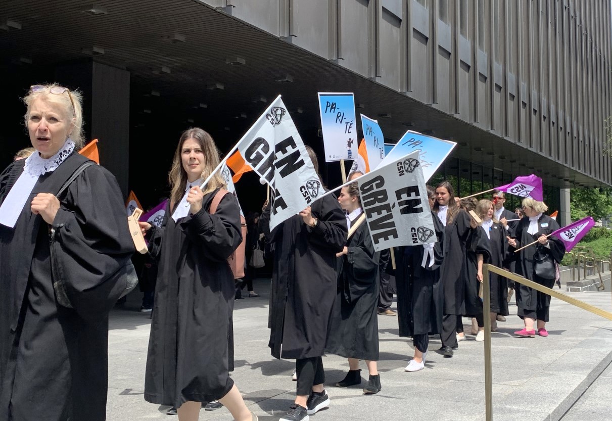 People wearing black robes with placards